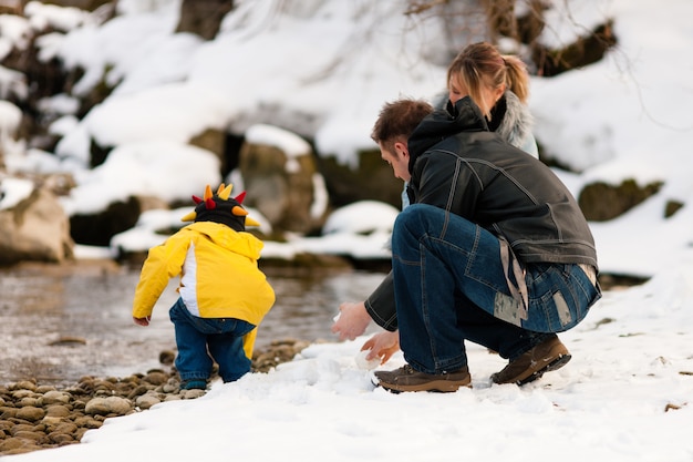 Famiglia che ha camminata di inverno al fiume