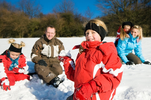 Famiglia che ha una lotta a palle di neve