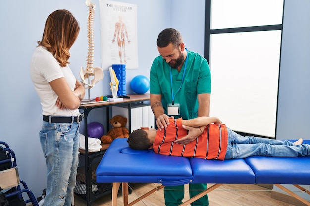 Famiglia che ha una sessione di fisioterapia che massaggia il bambino alla clinica di riabilitazione