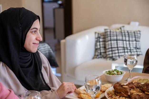 Famiglia che mangia insieme con membri di più generazioni in un salotto moderno