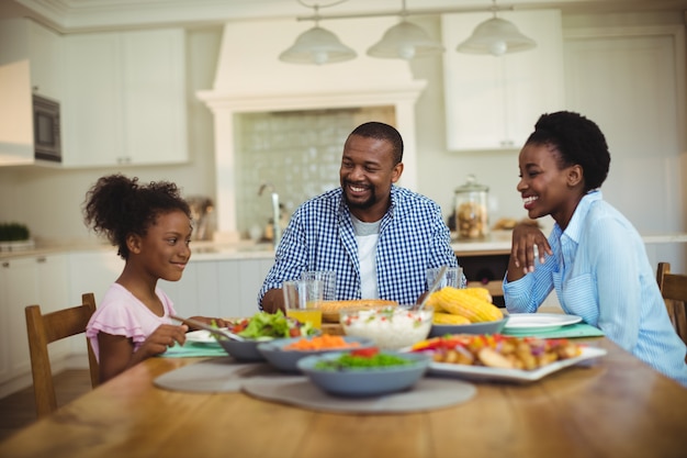 Famiglia che mangia pasto sulla tavola da pranzo a casa