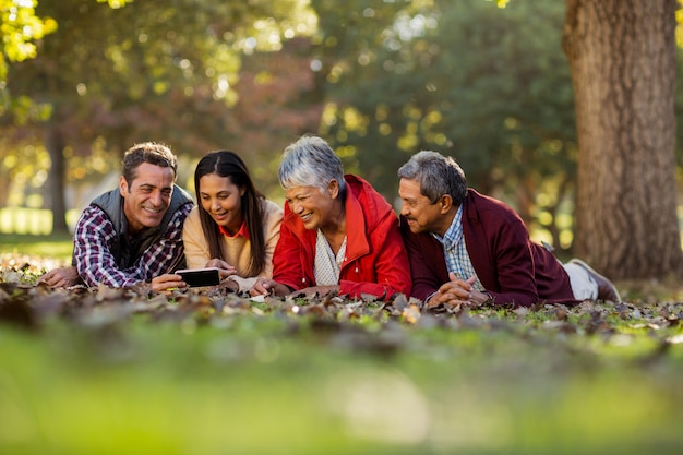 Famiglia che per mezzo del telefono cellulare al parco