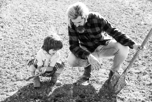 Famiglia che pianta un figlio dell'albero che aiuta padre, papà e bambino a fare giardinaggio in una pianta da giardino