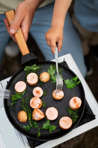 Famiglia che prepara la cena mentre è in campeggio