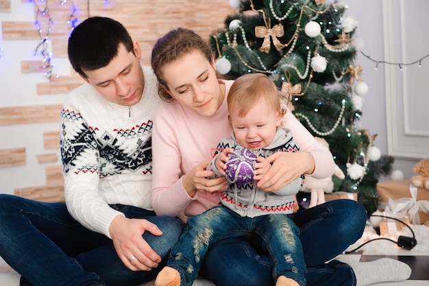 Famiglia che propone dall'albero di Natale