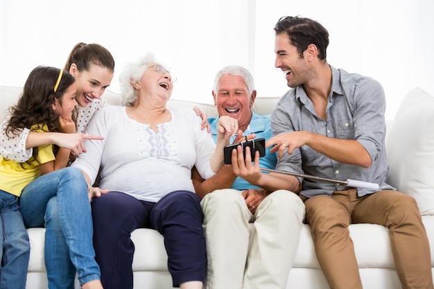 Famiglia che ride mentre guardando le foto dello smartphone