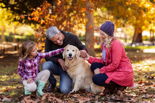 Famiglia che segna cane mentre accovacciato al parco