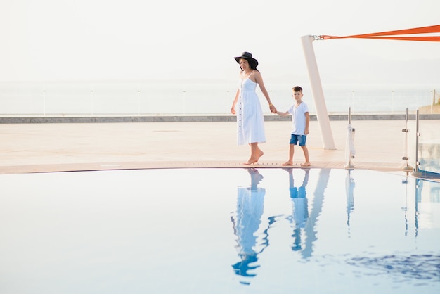 famiglia che si diverte vicino alla piscina in un resort tropicale di lusso, madre con bambino, vacanze estive.