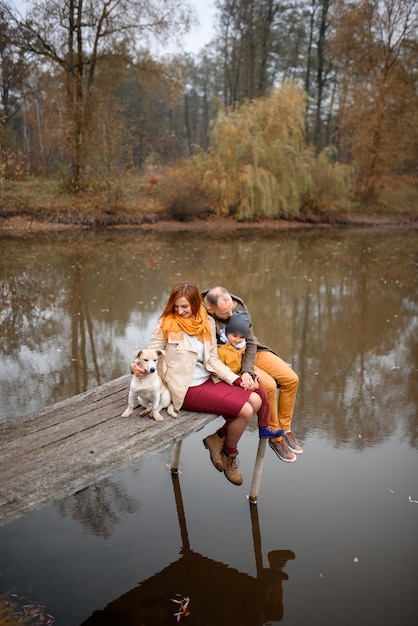 Famiglia che si rilassa all'interno e che segna il cane di animale domestico