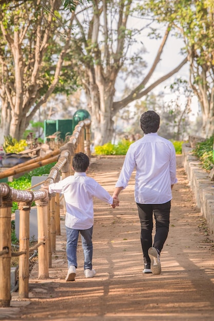 Famiglia che si tiene per mano mentre cammina in un parco durante il giorno a Lima in Perù