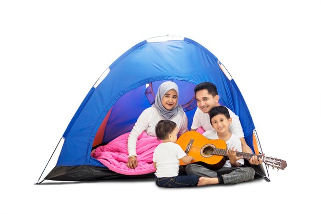 Famiglia che suona la chitarra in una tenda da campeggio