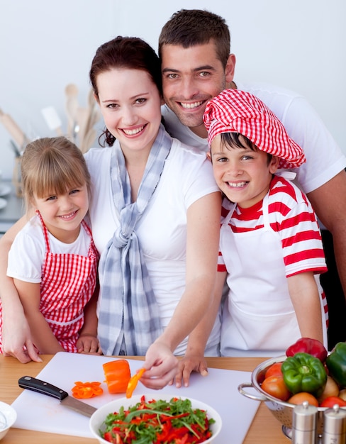 Famiglia che taglia le verdure variopinte in cucina