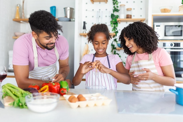 Famiglia con adorabili figlie riunite nella cucina moderna che cucinano insieme Goditi la comunicazione e il concetto di hobby di cucina