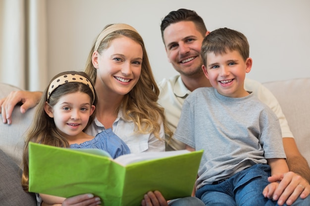 Famiglia con album di foto seduto sul divano