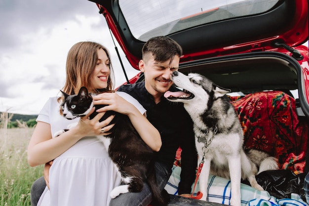 Famiglia con animali in natura sullo sfondo della sua auto