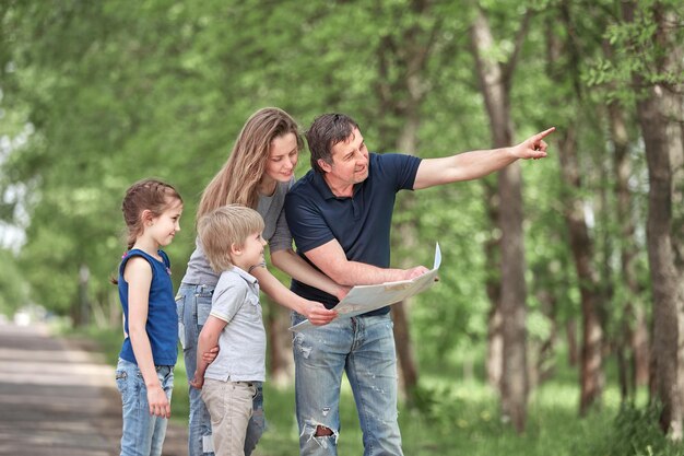 Famiglia con bambini che discutono del percorso di viaggio sulla mappa