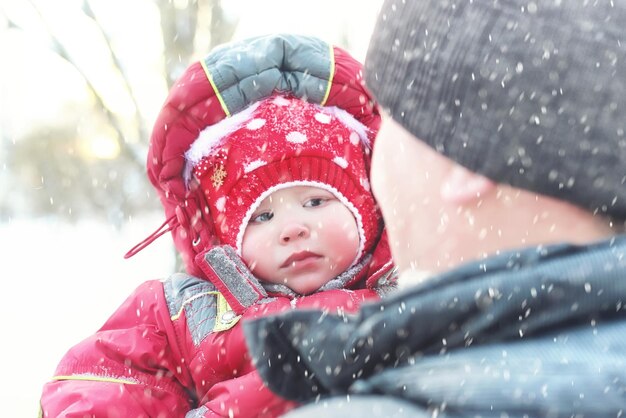 Famiglia con bambini nel parco in inverno bufera di neve