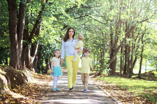 Famiglia con bambini per una passeggiata nel parco estivo. In arrivo l'autunno nel parco. Famiglia. Autunno. Felicità.