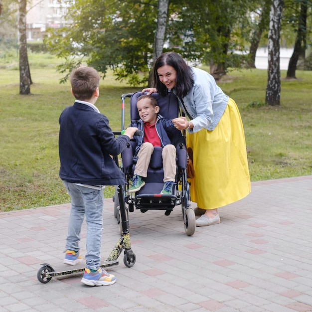 Famiglia con bambino affetto da paralisi cerebrale su sedia a rotelle con madre fratello