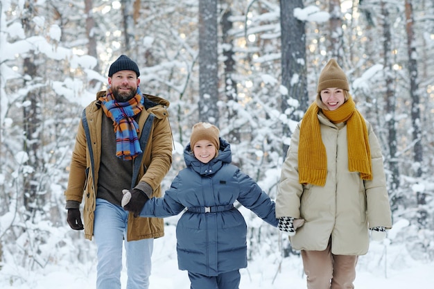 Famiglia con bambino che cammina in inverno