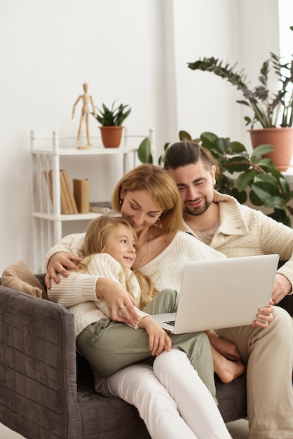 Famiglia con bambino che esamina computer portatile