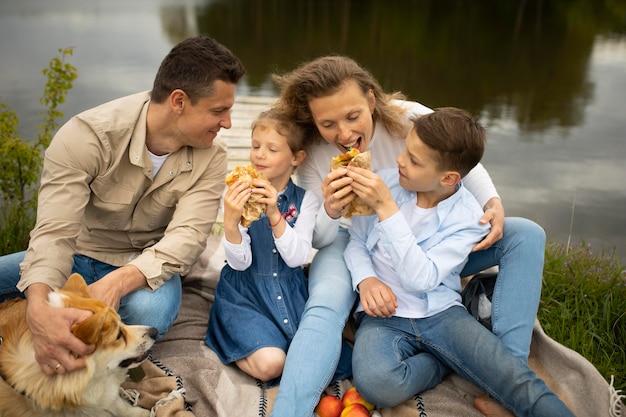 Famiglia con cane all'aperto colpo medio