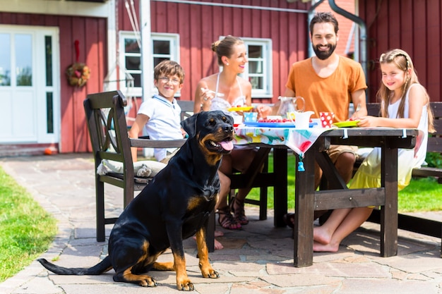 Famiglia con cane che mangia in giardino davanti alla casa