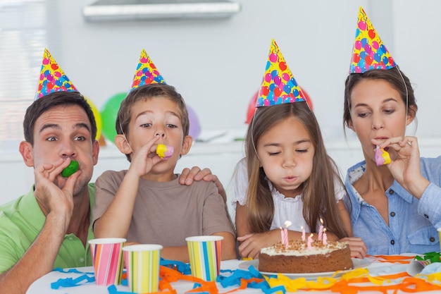 Famiglia con corno di festa che celebra la loro festa di figlia