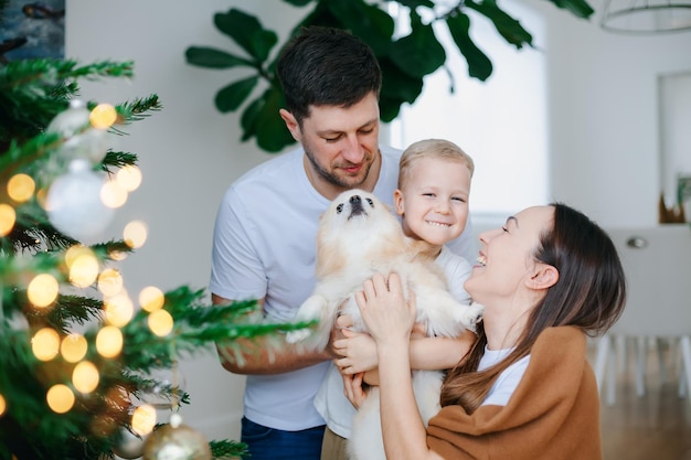 Famiglia con il cane vicino all'albero di Natale