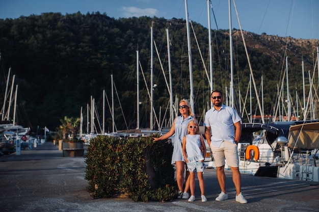 Famiglia con la figlia su un molo al lago in estate sulla strada per la pesca.