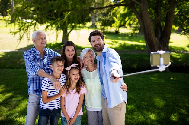 Famiglia di diverse generazioni che prende un selfie con il bastone del selfie