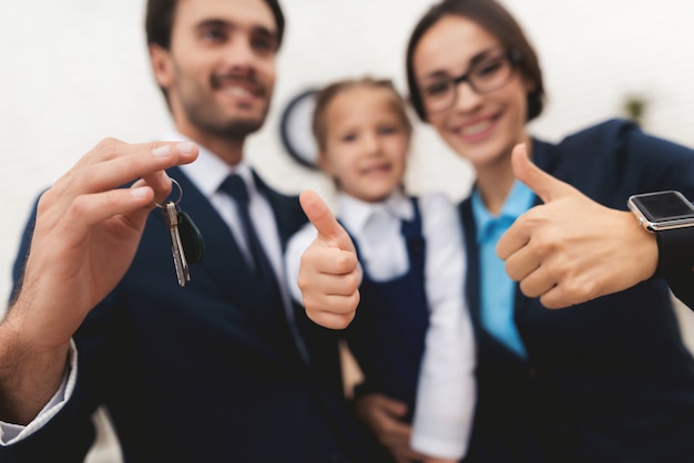 Famiglia di persone di affari che tengono chiave a casa.