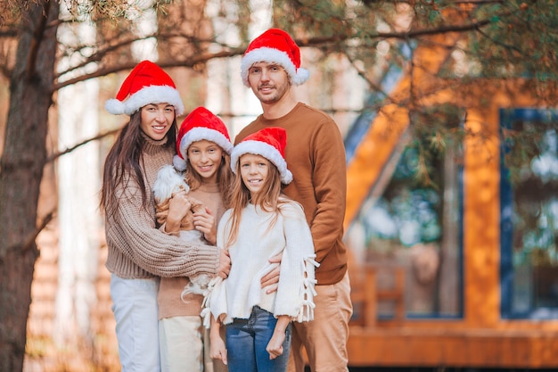 Famiglia di quattro felice in cappello della Santa che gode delle vacanze di Natale