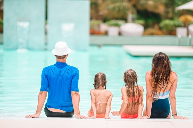 Famiglia di quattro felice nella piscina all'aperto