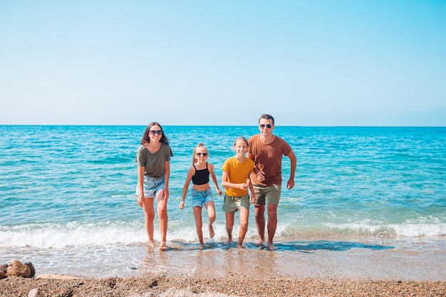 Famiglia di quattro persone che si divertono insieme sulla spiaggia