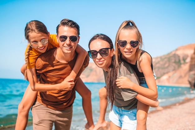 Famiglia di quattro persone che si divertono insieme sulla spiaggia