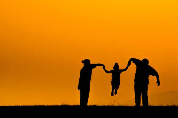 famiglia di sagoma su sfondo di erba al tramonto