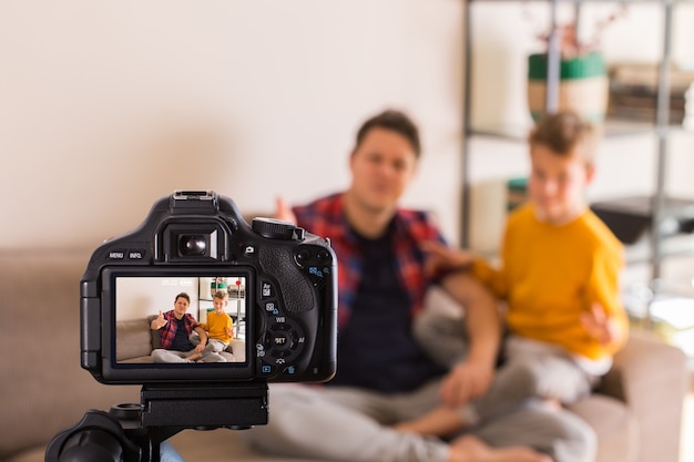 Famiglia di vlogger che registra video sui social media mentre è seduto sul divano