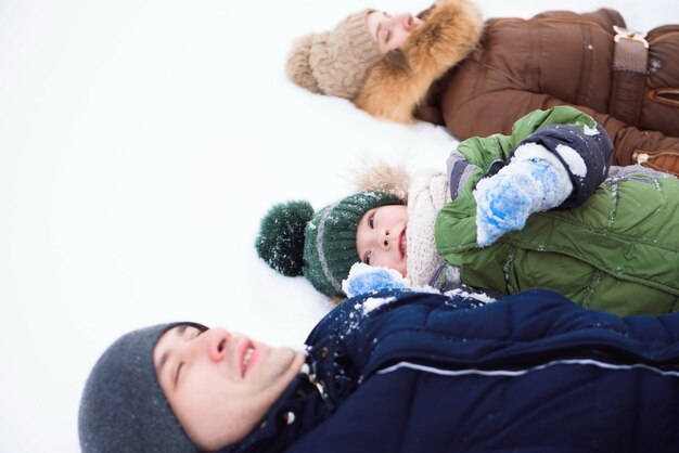 Famiglia divertendosi, giocando in inverno a piedi all'aperto