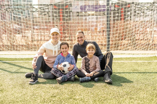 famiglia e palla sull'erba nello stadio.