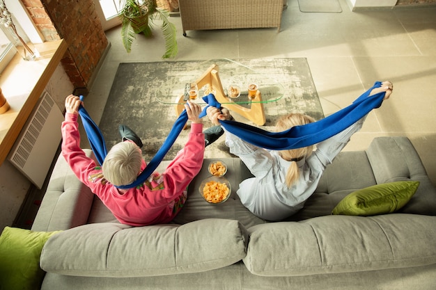 Famiglia eccitata che guarda il calcio, partita sportiva a casa. Nonna e figlia tifo emotivo per la nazionale di basket, calcio, tennis, calcio, squadra di hockey. Concetto di emozioni, supporto, tifo.