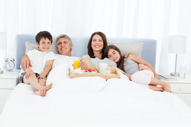 Famiglia facendo colazione nel loro letto