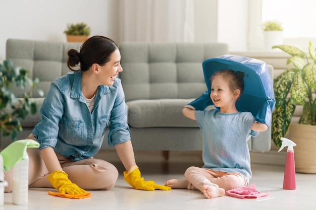 Famiglia felice a casa. Madre e figlia che fanno le pulizie in casa.