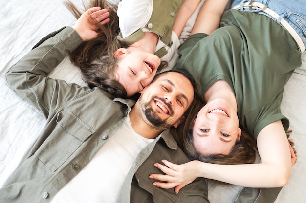 Famiglia felice a casa madre padre figli figlia rilassata a letto a casa indoor madre padre genitori