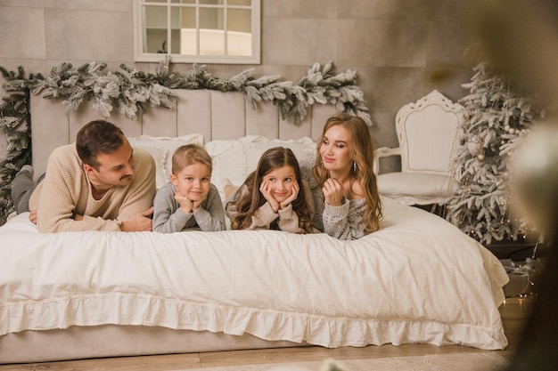 Famiglia felice a casa sul letto Concetto di nuovo anno