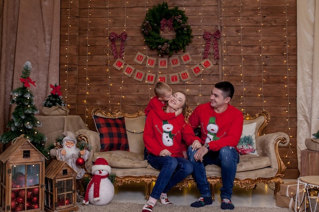 Famiglia felice a casa vicino all'albero di Natale