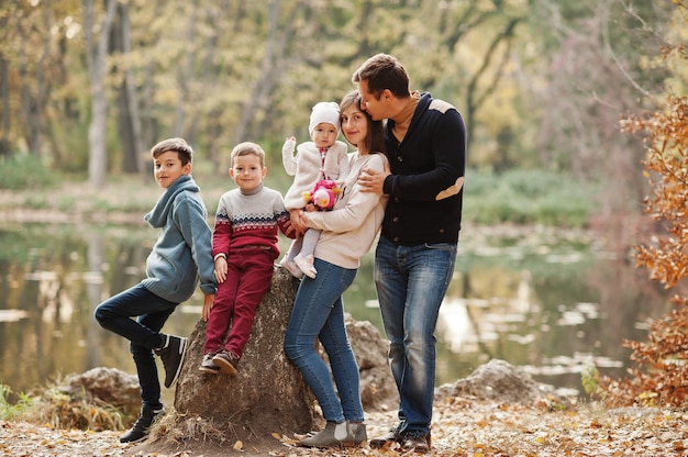 Famiglia felice al parco delle foglie d'autunno. Tre bambini.