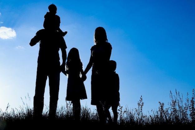 Famiglia felice all'aperto nella silhouette del parco
