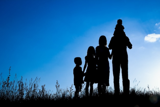 Famiglia felice all'aperto nella silhouette del parco