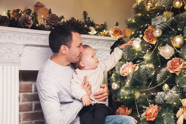 Famiglia felice all'interno di una casa sullo sfondo dell'albero di Natale con regali